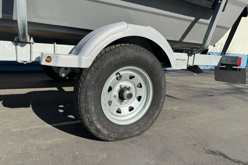 Slide: The Image of Trailer wheel of 2017 RH Boats 18 SH on pavement, close-up view. - 1