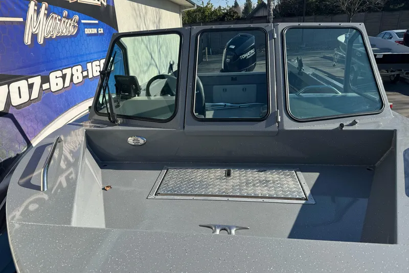 Slide: The Image of 2017 RH Boats 18 SH with windshield and Tohatsu motor, parked outdoors. - 4