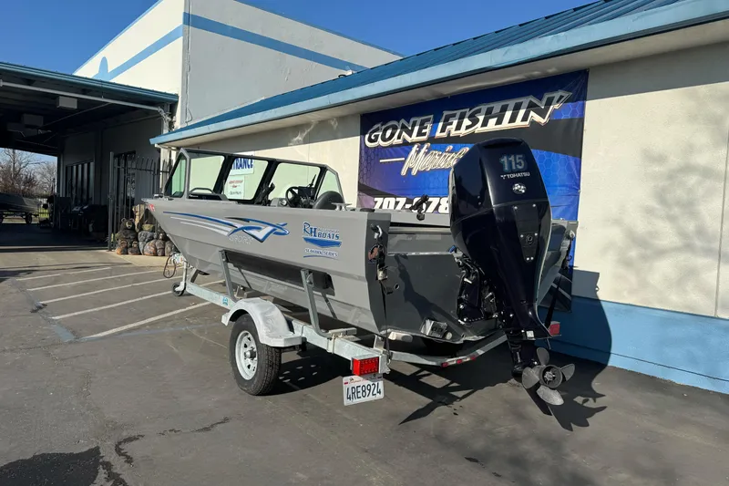 Slide: The Image of 2017 RH Boats 18 SH with Tohatsu 115 engine on trailer outside dealership. - 5