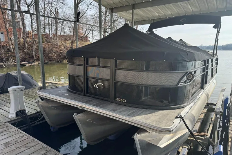 Slide: The Image of 2022 Crest Classic Platinum 220 SLRC pontoon boat docked under a canopy. - 2