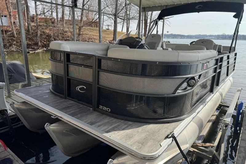 Slide: The Image of 2022 Crest Classic Platinum 220 SLRC pontoon boat docked by a lakeside. - 4