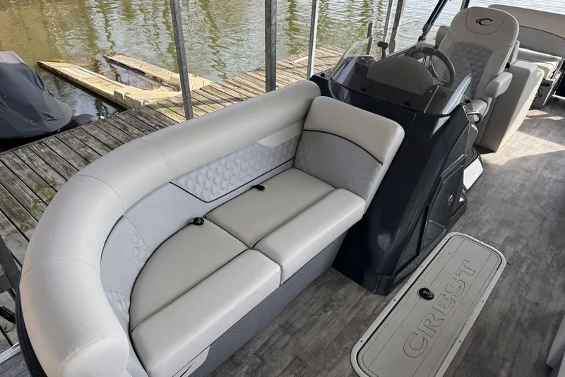 Slide: The Image of 2022 Crest Classic Platinum 220 SLRC boat interior with plush seating and steering console. - 7