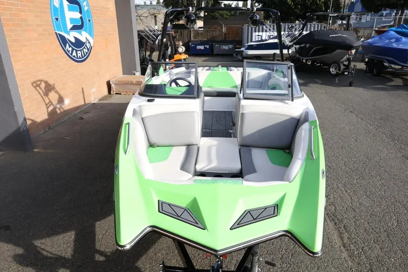 Slide: The Image of 2016 Tigé R22 boat with green and white interior, parked outdoors. - 11