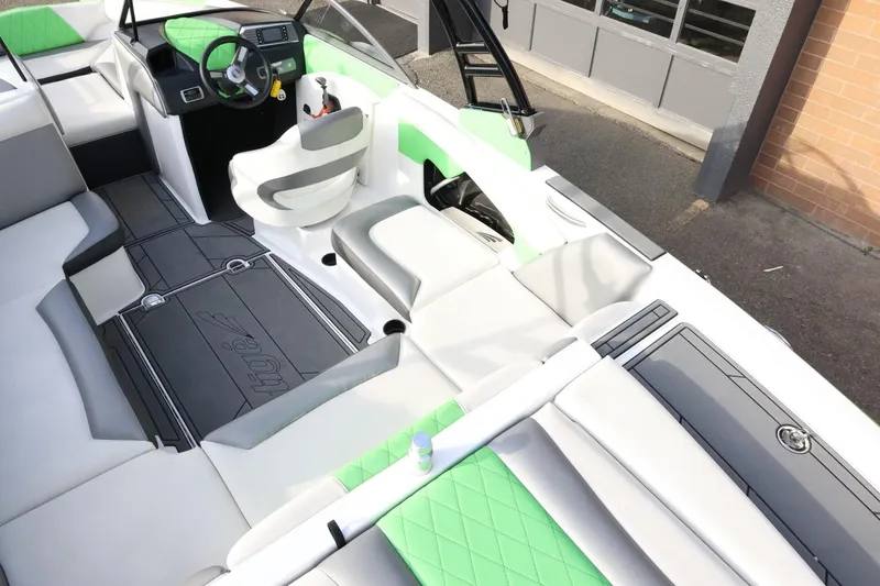 Slide: The Image of 2016 Tigé R22 boat interior with green and gray seating, modern dashboard, and spacious layout. - 13