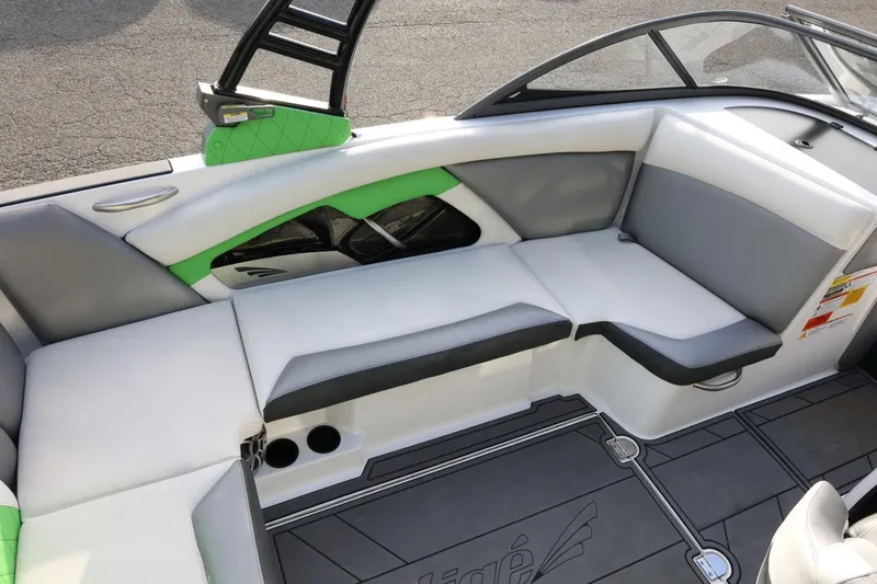 Slide: The Image of 2016 Tigé R22 boat interior with gray and green seating, cup holders, and sleek design. - 14