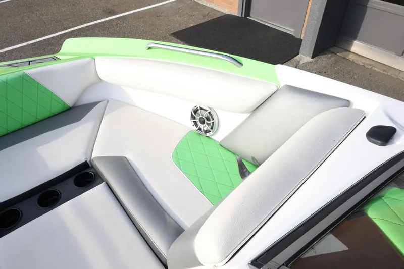 Slide: The Image of 2016 Tigé R22 boat interior with green and white seating, cup holders, and speaker. - 17