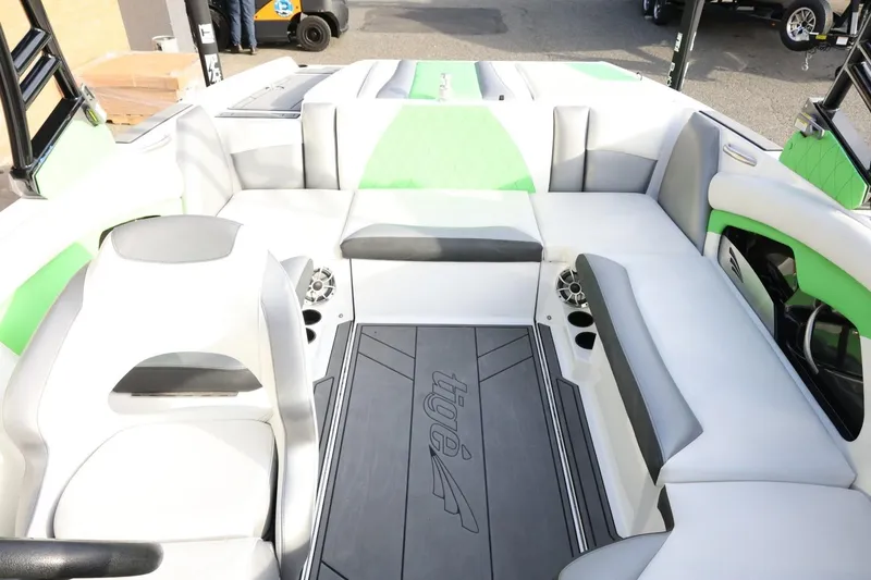 Slide: The Image of 2016 Tigé R22 boat interior with green and white seating, cup holders, and speakers. - 21