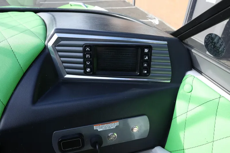 Slide: The Image of 2016 Tigé R22 boat dashboard with green upholstery and control panel. - 24