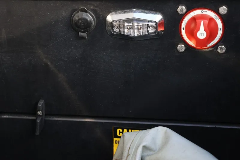Slide: The Image of Control panel of a 2016 Tigé R22 boat with switches and warning label. - 27