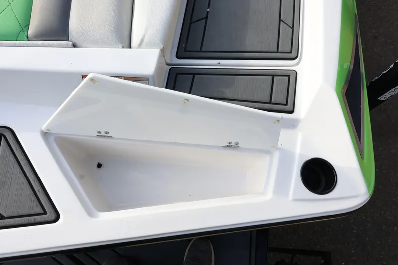 Slide: The Image of 2016 Tigé R22 boat storage compartment with open lid and cup holder. - 32