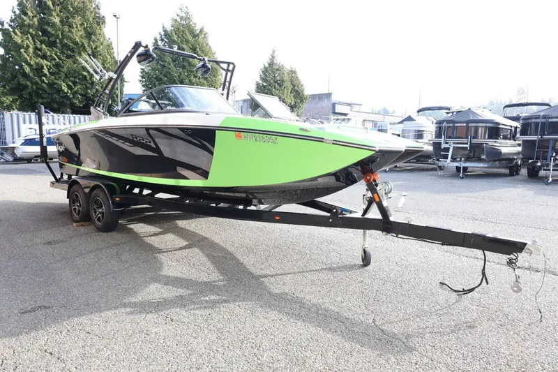 Slide: The Image of 2016 Tigé R22 boat in vibrant green and black on a trailer, parked outdoors. - 5