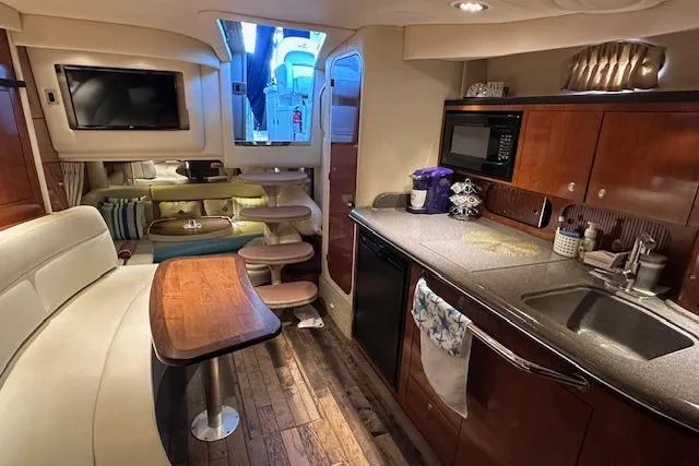 Slide: The Image of Luxurious 2007 Sea Ray 340 Sundancer interior with kitchen, seating, and entertainment area. - 19