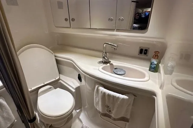 Slide: The Image of Luxurious bathroom in 2007 Sea Ray 340 Sundancer yacht with sink, toilet, and storage cabinets. - 24
