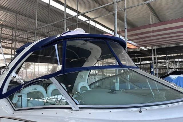 Slide: The Image of 2007 Sea Ray 340 Sundancer boat in covered marina, featuring blue canopy and sleek design. - 4