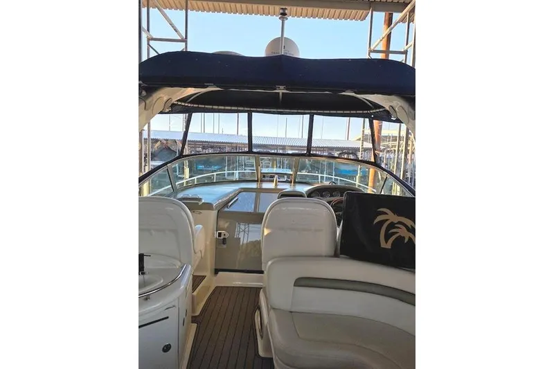 Slide: The Image of 2007 Sea Ray 340 Sundancer cockpit with seating and helm, docked under a canopy. - 42