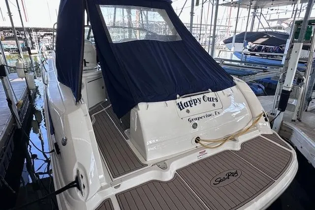 Slide: The Image of 2007 Sea Ray 340 Sundancer docked, featuring a covered cockpit and teak swim platform. - 6