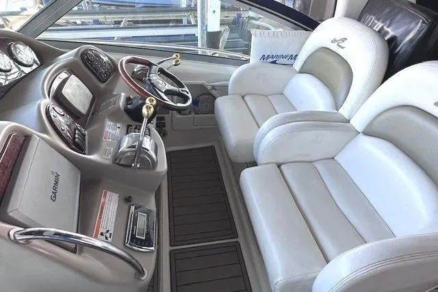 Slide: The Image of 2007 Sea Ray 340 Sundancer cockpit with dual white leather seats and modern controls. - 8