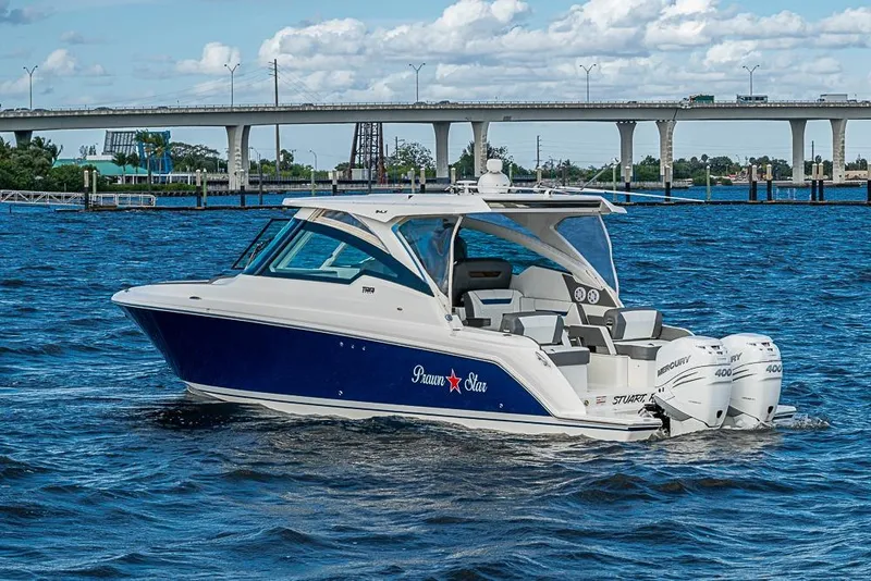 Slide: The Image of 2022 Tiara Yachts 34 LX boat cruising on water with twin Mercury 400 engines. - 16