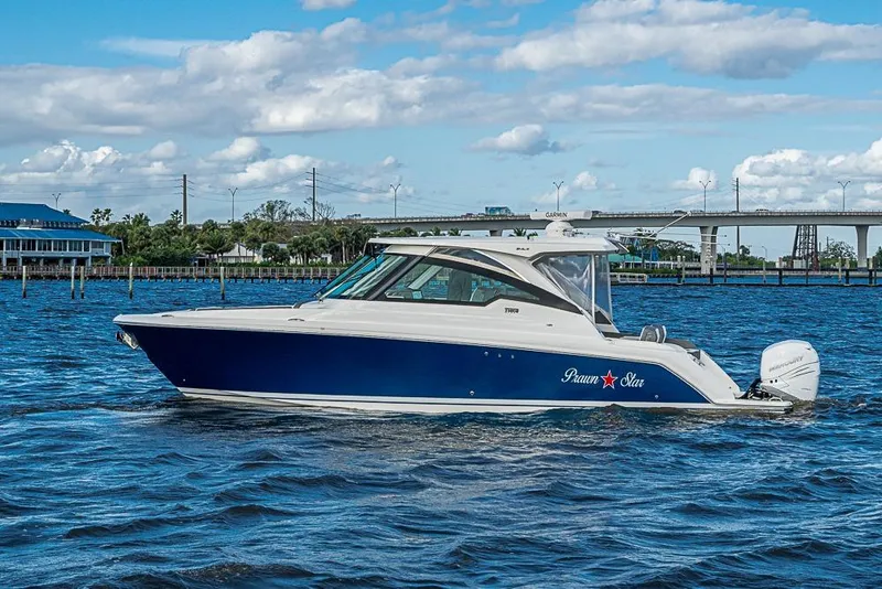 Slide: The Image of 2022 Tiara Yachts 34 LX cruising on a sunny day near a bridge. - 18
