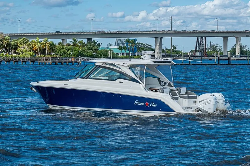 Slide: The Image of 2022 Tiara Yachts 34 LX cruising on a sunny day near a bridge. - 3