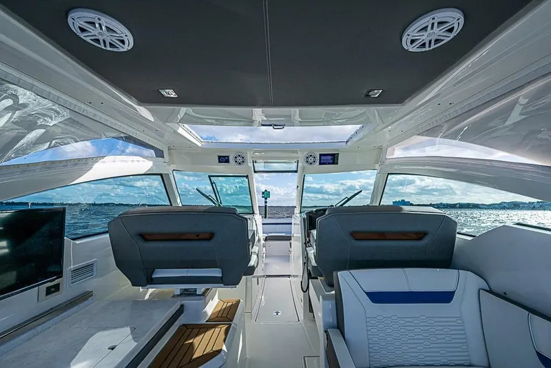 Slide: The Image of Interior view of 2022 Tiara Yachts 34 LX, showcasing helm and panoramic windows. - 36