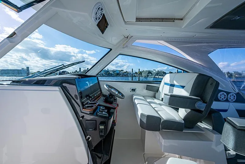 Slide: The Image of Interior view of 2022 Tiara Yachts 34 LX, featuring modern seating and ocean backdrop. - 37