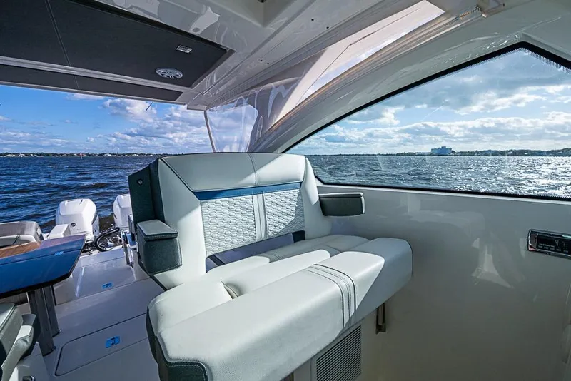 Slide: The Image of 2022 Tiara Yachts 34 LX interior with modern helm and seating, overlooking water. - 38