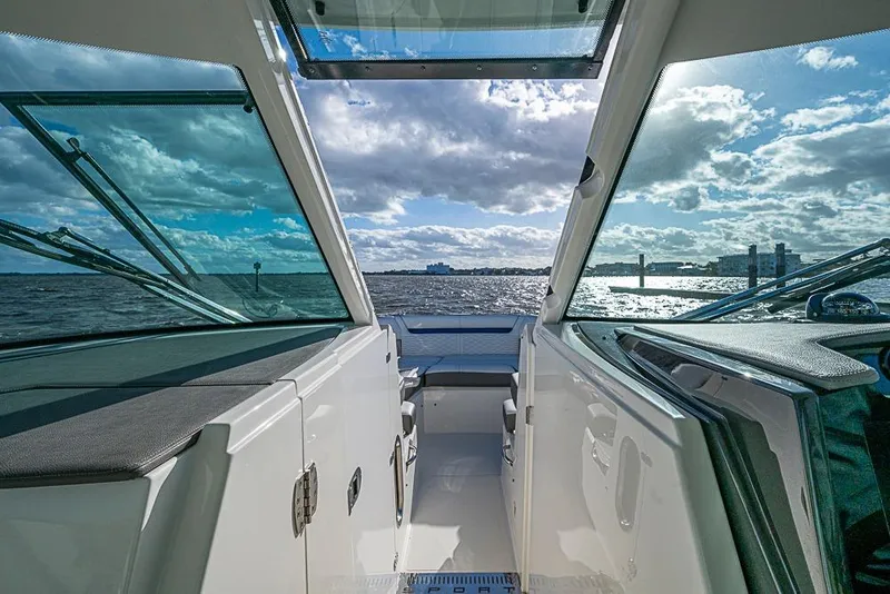 Slide: The Image of Cockpit view of 2022 Tiara Yachts 34 LX, featuring modern controls and scenic water backdrop. - 42