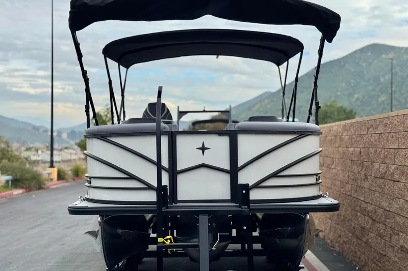 Slide: The Image of 2026 Berkshire 21CL STS pontoon boat on a trailer, scenic mountain backdrop. - 2