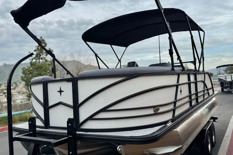 Slide: The Image of 2026 Berkshire 21CL STS pontoon boat with sleek design and canopy, parked outdoors. - 3