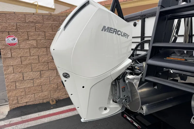 Slide: The Image of 2026 Berkshire 21CL STS with Mercury outboard motor, parked near a brick wall. - 7