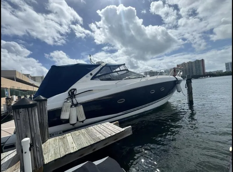 Slide: The Image of 2003 Sunseeker Portofino 46 yacht docked under a partly cloudy sky. - 2