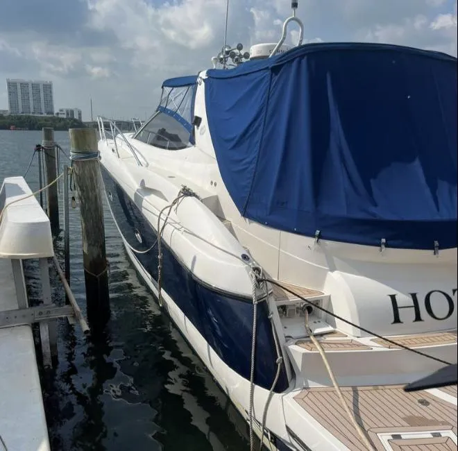Slide: The Image of 2003 Sunseeker Portofino 46 yacht docked, featuring blue covers and sleek design. - 29