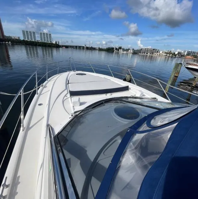 Slide: The Image of 2003 Sunseeker Portofino 46 yacht on calm water, clear sky, cityscape background. - 32