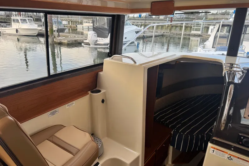 Slide: The Image of Interior of 2021 Ranger Tugs R-27 boat with seating and cabin view at marina. - 10