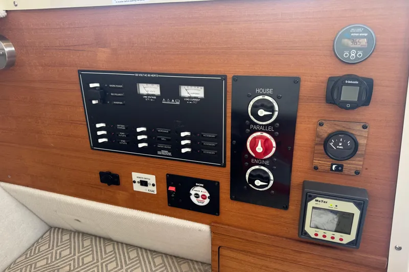 Slide: The Image of Electrical control panel on a 2021 Ranger Tugs R-27 boat, featuring various switches and gauges. - 19