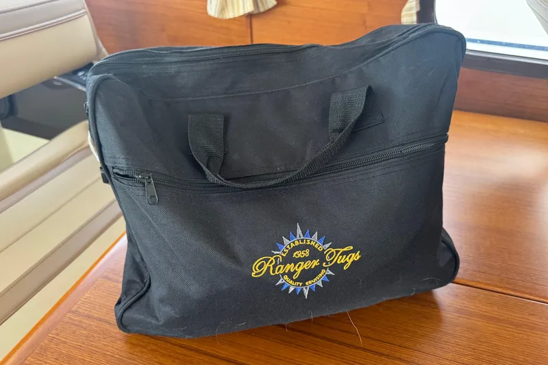 Slide: The Image of Black Ranger Tugs bag on wooden surface, showcasing embroidered logo. - 21