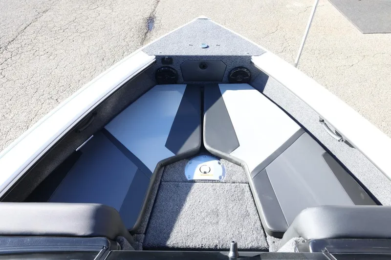 Slide: The Image of 2026 Lund 1875 Crossover XS boat interior with cushioned seating and storage compartments. - 16