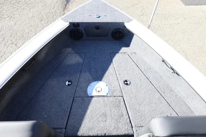 Slide: The Image of 2026 Lund 1875 Crossover XS boat interior with carpeted deck and storage compartments. - 17