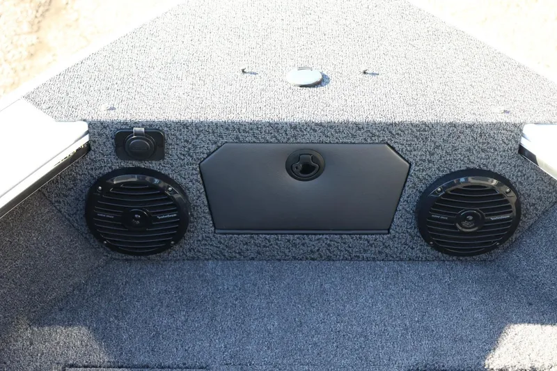 Slide: The Image of 2026 Lund 1875 Crossover XS boat interior with speakers and storage compartment. - 21