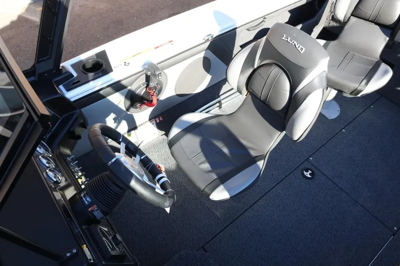 Slide: The Image of 2026 Lund 1875 Crossover XS boat interior with steering wheel and seating. - 22