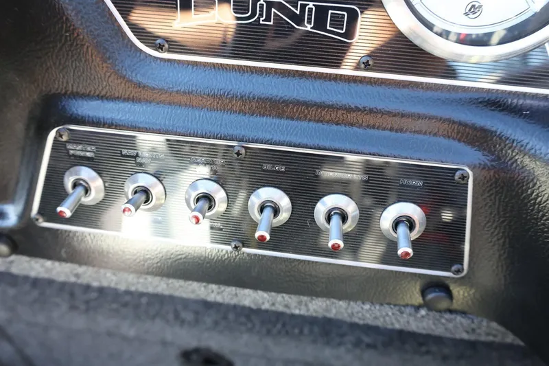Slide: The Image of Control panel of 2026 Lund 1875 Crossover XS boat with toggle switches. - 26