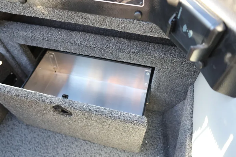 Slide: The Image of 2026 Lund 1875 Crossover XS boat storage compartment with open lid, showcasing interior space. - 30