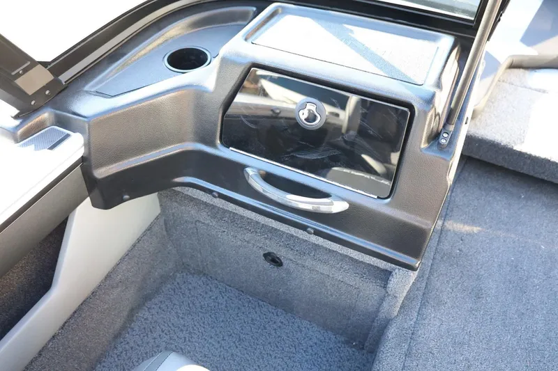 Slide: The Image of 2026 Lund 1875 Crossover XS boat interior with storage compartment and cup holder. - 31