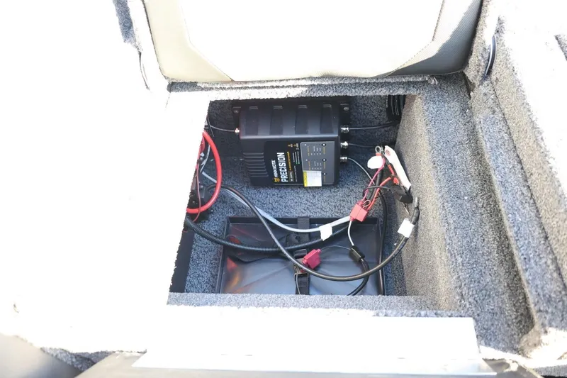 Slide: The Image of 2026 Lund 1875 Crossover XS battery compartment with wiring and charger. - 44