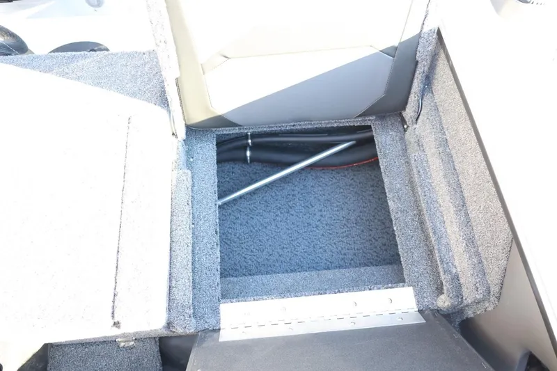 Slide: The Image of 2026 Lund 1875 Crossover XS boat storage compartment with carpeted interior. - 45