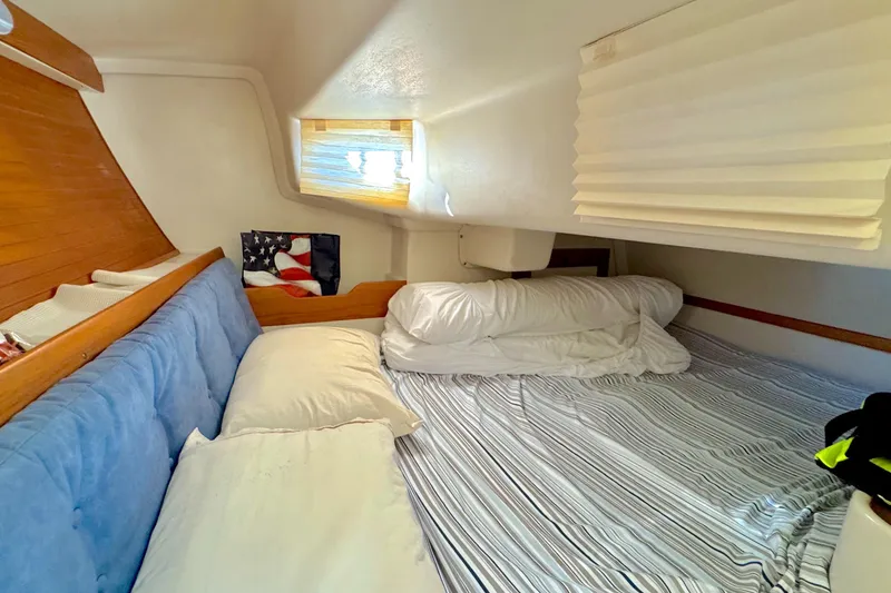 Slide: The Image of Cozy cabin interior of 1995 Catalina 320 sailboat with striped bedding and wooden accents. - 11