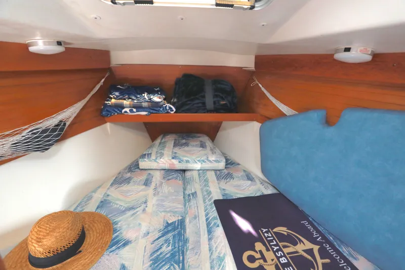 Slide: The Image of Cozy cabin interior of a 1995 Catalina 320 sailboat with bedding and storage. - 12