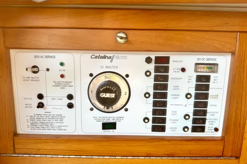 Slide: The Image of Electrical control panel of a 1995 Catalina 320 yacht with various switches and indicators. - 15