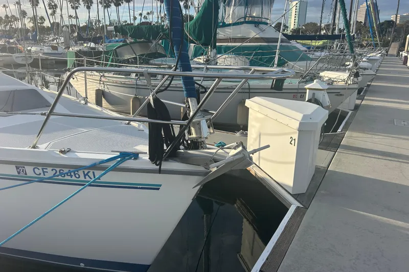 Slide: The Image of Sailboats docked in marina, featuring a 1995 Catalina 320 with blue covers. - 2